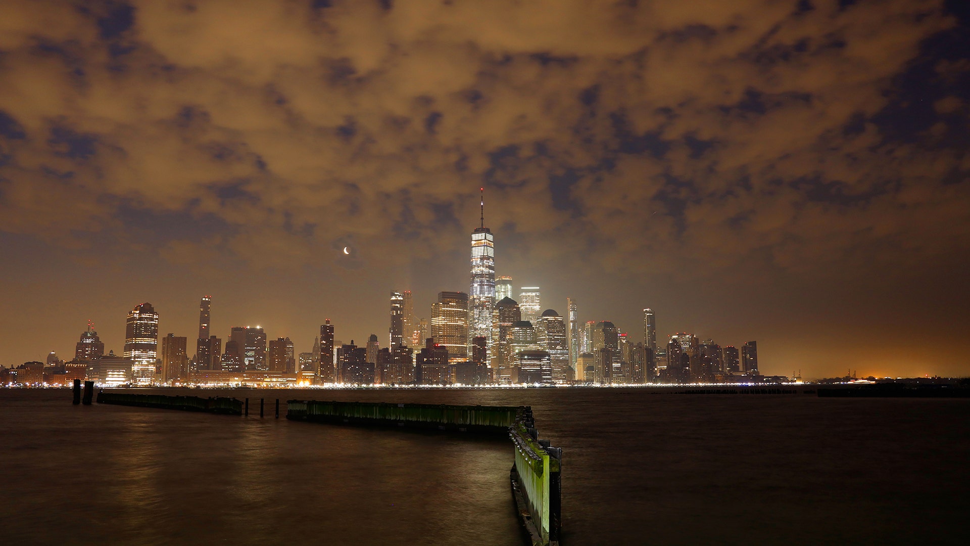 Haze from a forest fire in New Jersey drifts through the air as a crescent moon rises behind the skyline of lower Manhattan before sunrise in New York City, March 31, 2019 as seen from Jersey City, N.J. 