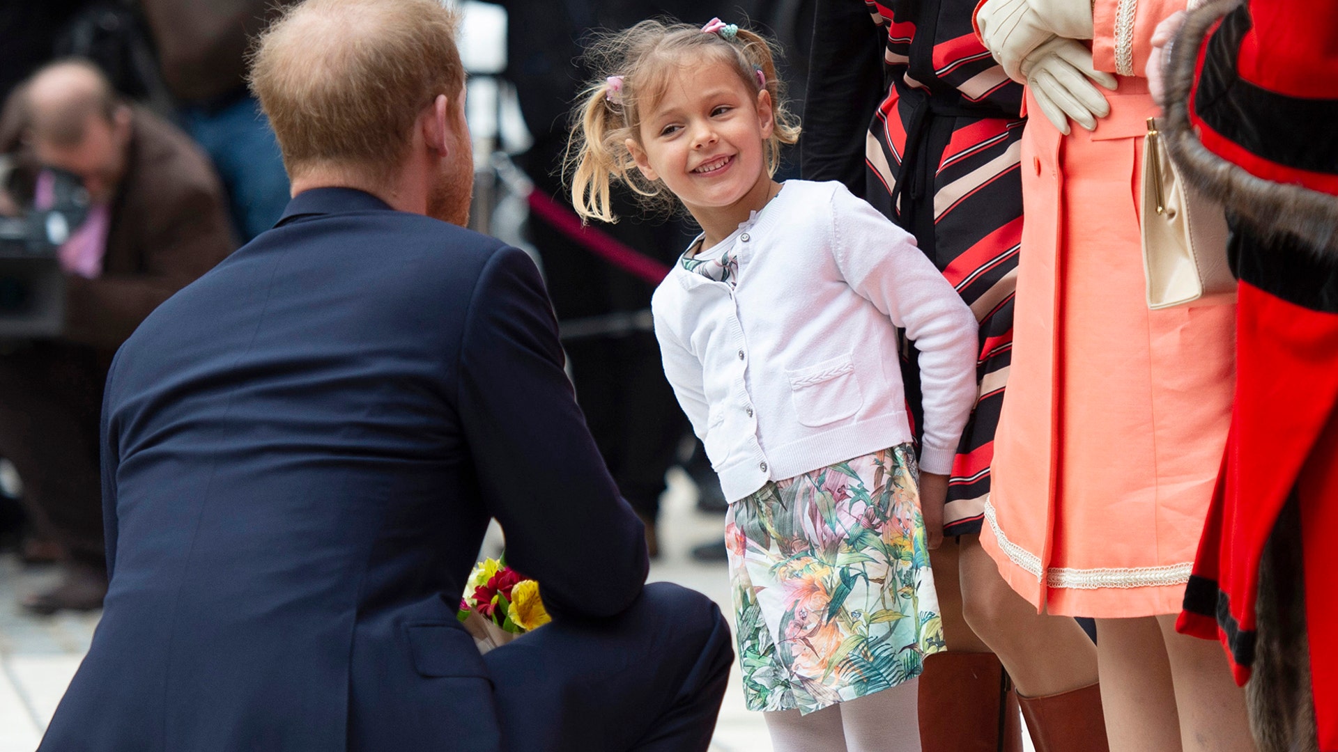 Britain's Prince Harry, the Duke of Sussex is presented with a posey by Zofia Zdenkowska, as he attends the Lord Mayor's Big Curry at the Guildhall, London, April 4, 2019. 