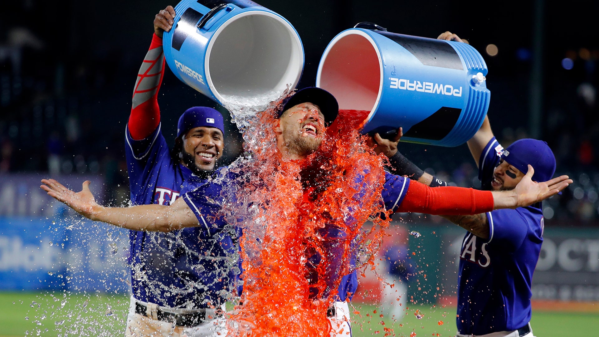 Texas Rangers' Hunter Pence is doused by Elvis Andrus and Rougned Odor following the team's baseball game against the Houston Astros in Arlington, Texas, April 3, 2019.