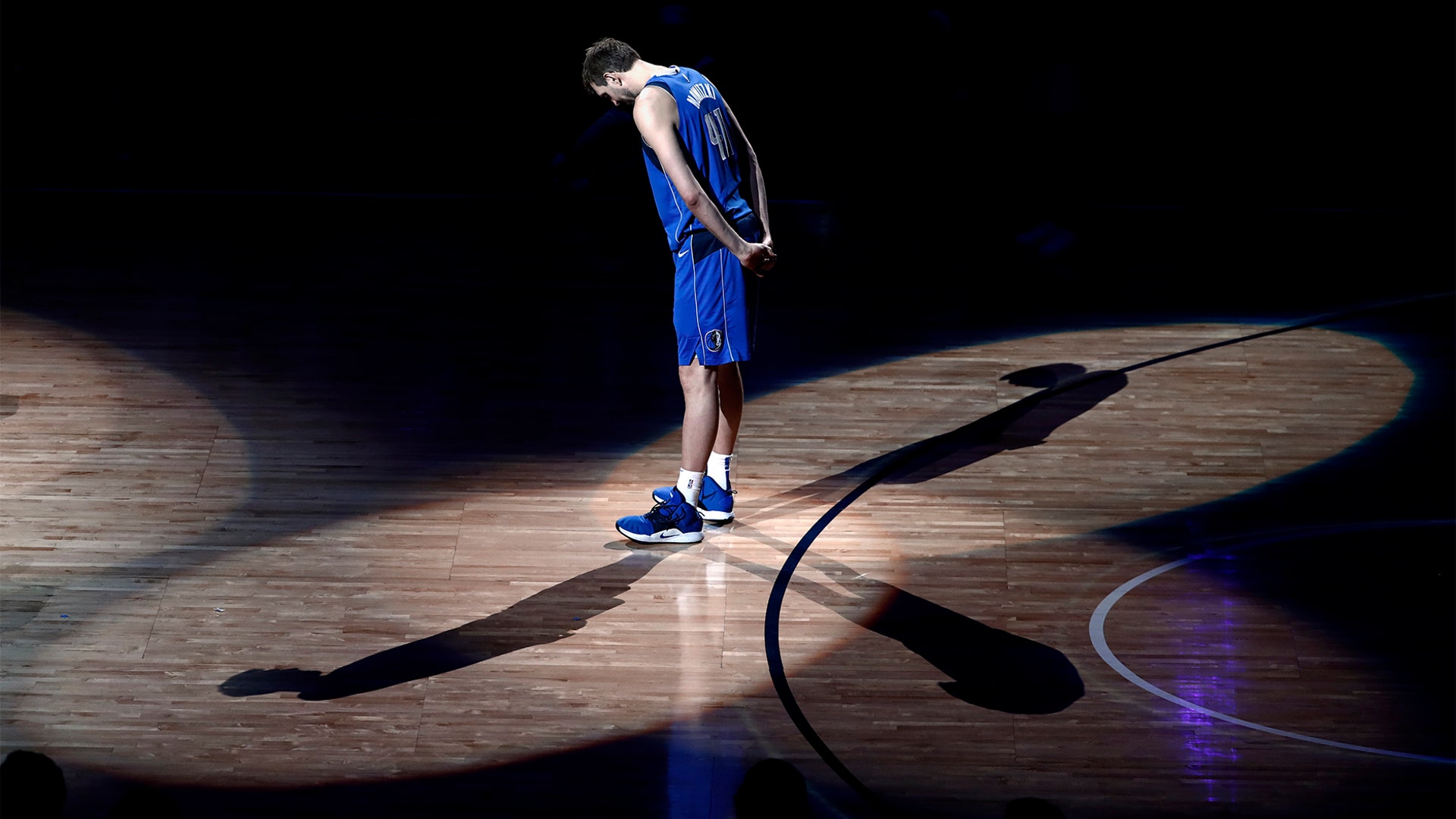 Dallas Mavericks forward Dirk Nowitzki stands on the court listening as former players pay tribute to him after his final home game in Dallas, April 9, 2019. 