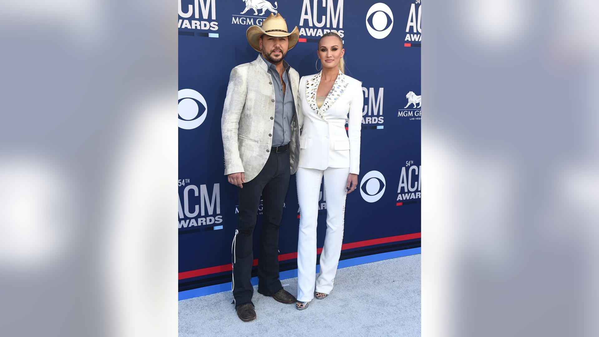 Jason Aldean and Brittany Kerr Aldean color coordinate in white outfits.