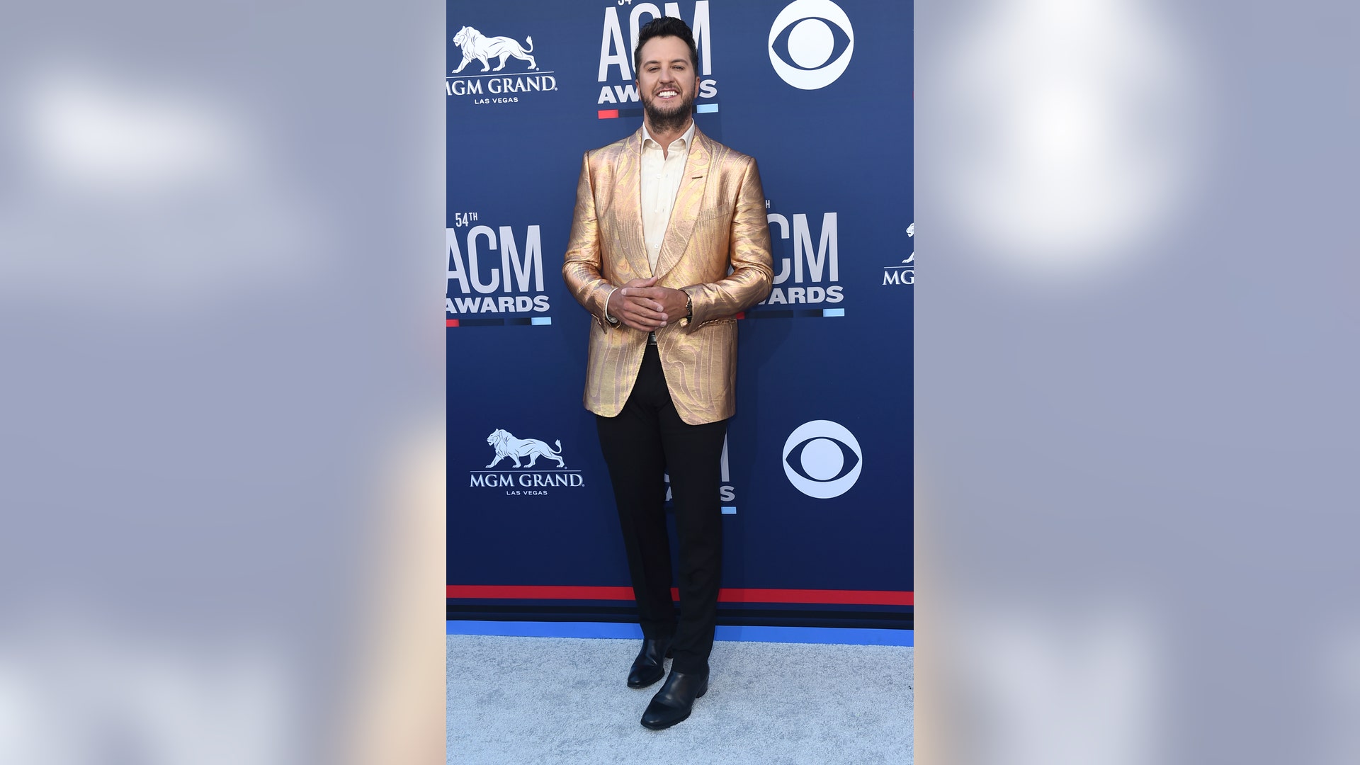 Luke Bryan shimmers on the red carpet in a gold suit.