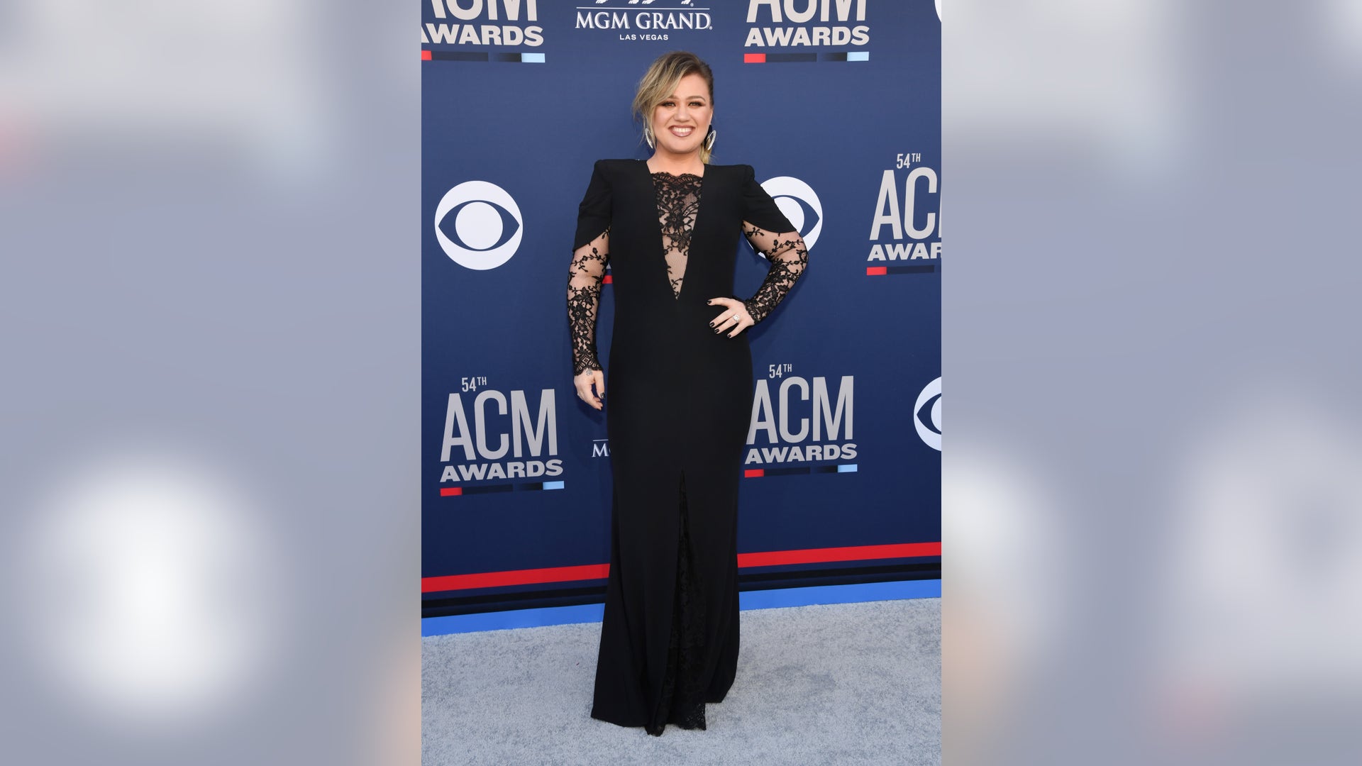 Kelly Clarkson is all smiles in a black gown with lace detailing.