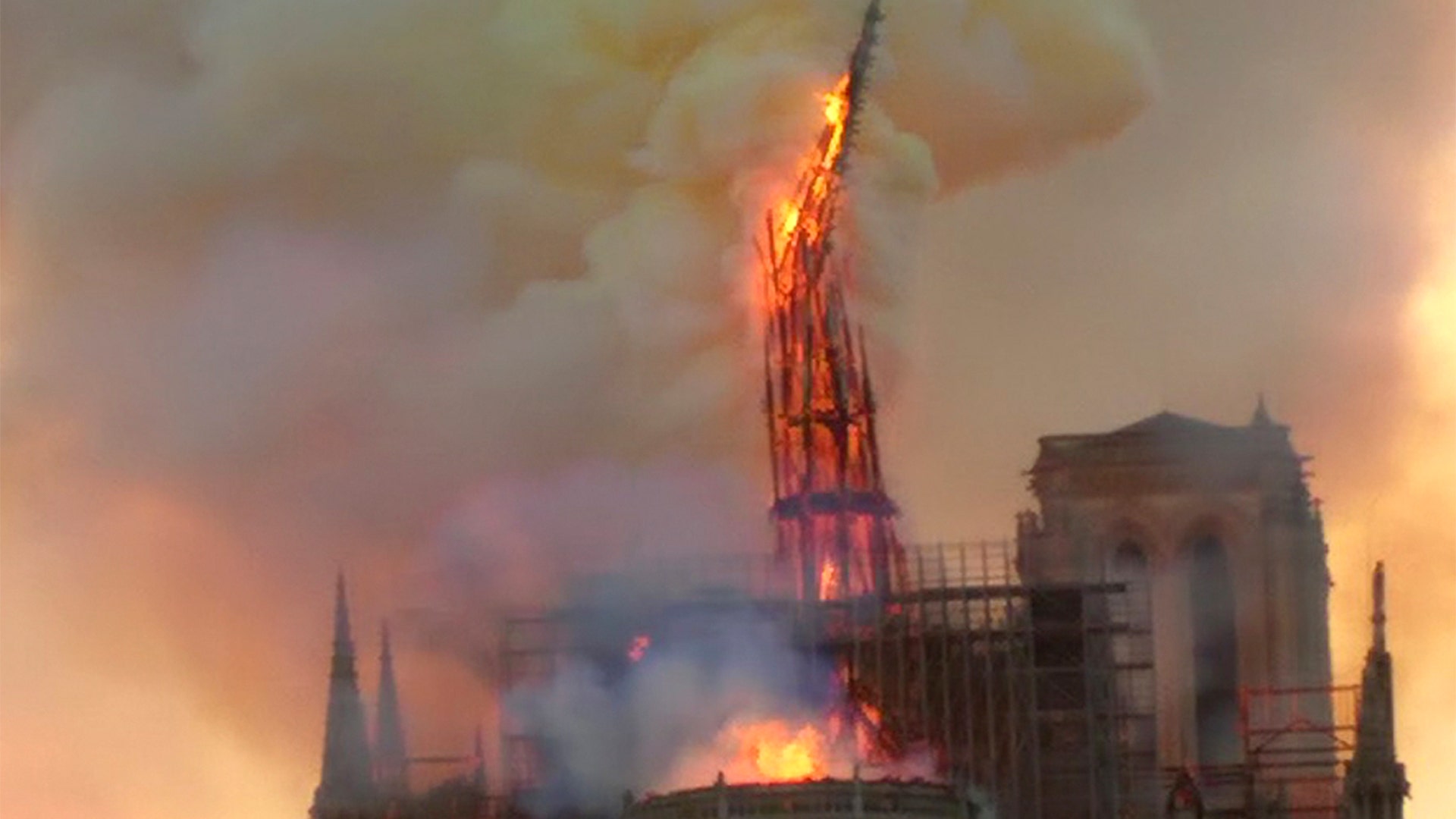 Flames and smoke rise as the spire of Notre Dame Cathedral collapses.