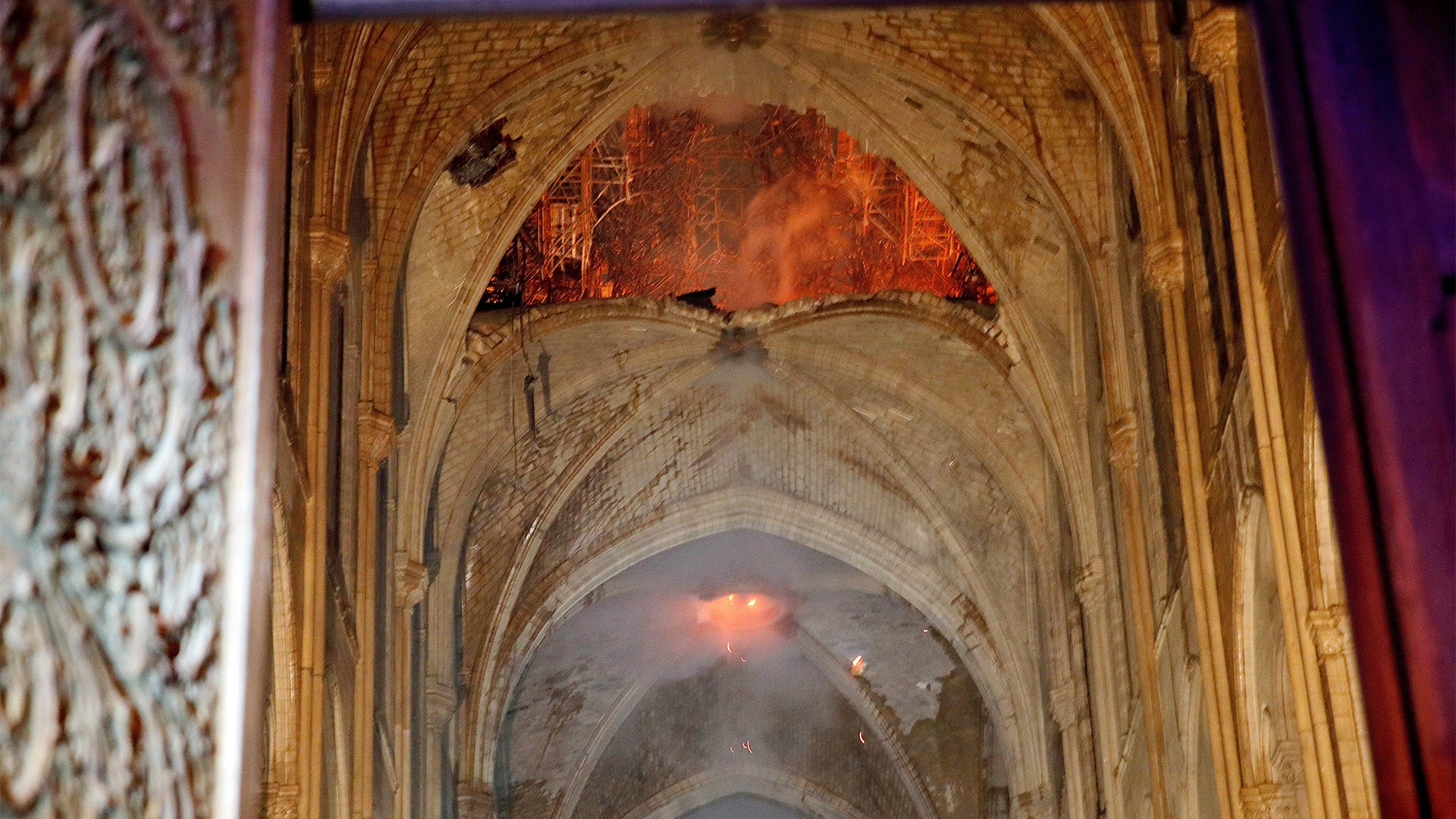 Flames and smoke are seen in the interior of Notre Dame Cathedral.