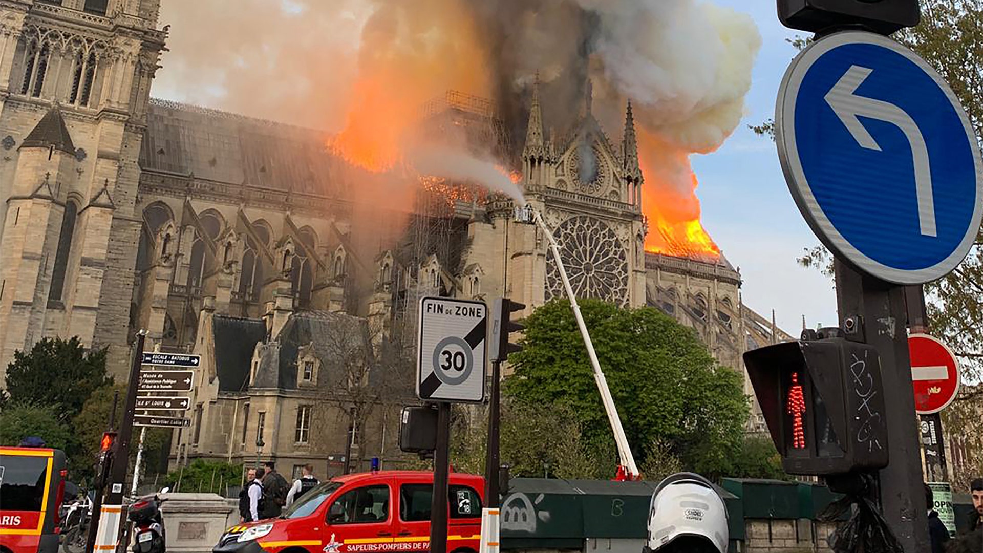 Flames and smoke are seen billowing from the roof at Notre Dame Cathedral.