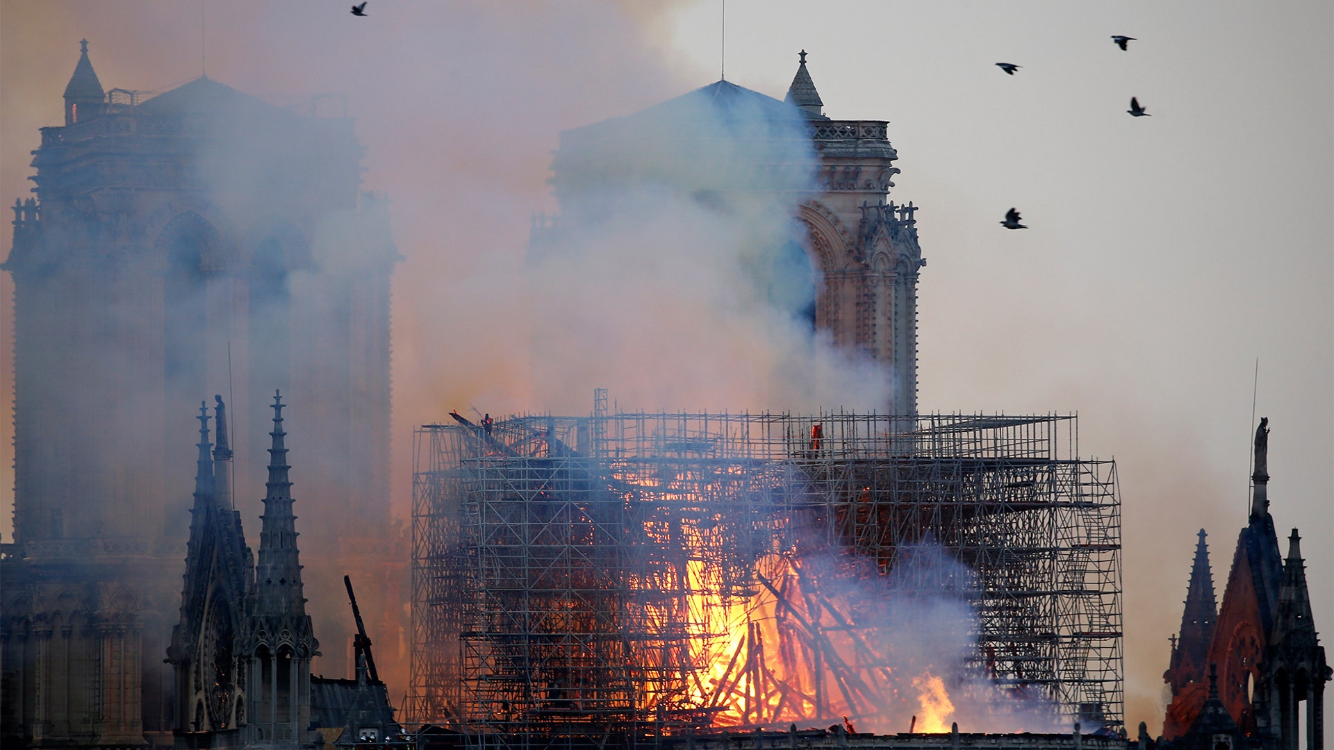 Flames and smoke are seen billowing from the roof at Notre Dame Cathedral.