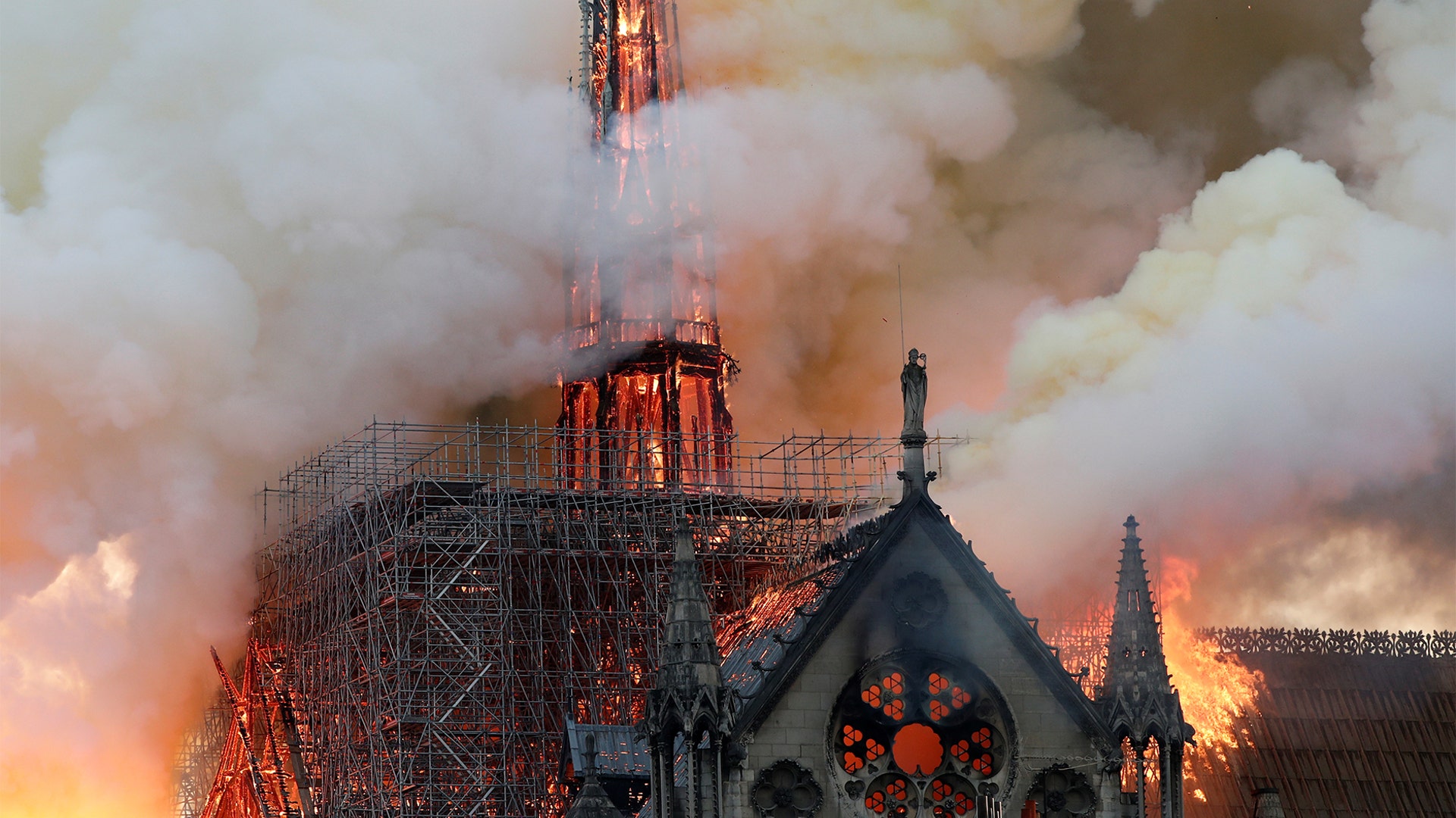 Smoke billows as the fire engulfs the spire of Notre Dame Cathedral in Paris.