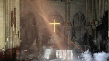 Notre Dame’s golden altar cross seen glowing as images emerge from inside showing fire-ravaged cathedral