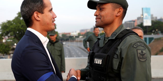 Venezuelan opposition leader Juan Guaido, who many nations have recognized as the country's rightful interim ruler, shakes hands with a military member near the Generalissimo Francisco de Miranda Airbase "La Carlota", in Caracas, Venezuela April 30, 2019. REUTERS/Carlos Garcia Rawlins - RC197DFD5580