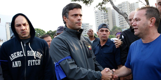 Opposition leader Leopoldo Lopez, center, is greeted by a supporter in Caracas Tuesday. (AP Photo/Ariana Cubillos)