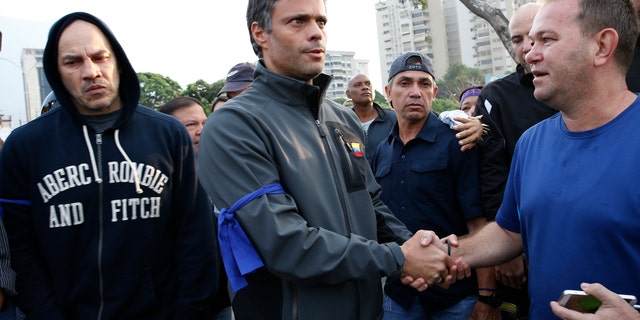 Opposition leader Leopoldo Lopez, center, is greeted by a supporter in Caracas Tuesday. (AP Photo/Ariana Cubillos)