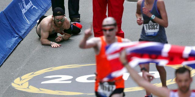Micah Herndon crawls to the finish line in the 123rd Boston Marathon on Monday in Boston.