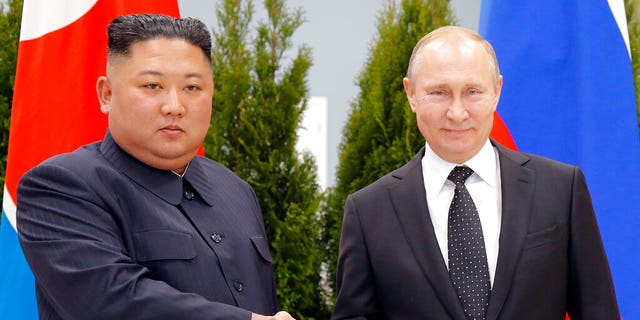 Russian President Vladimir Putin, right, and North Korea's leader Kim Jong Un shake hands during their meeting in Vladivostok, Russia