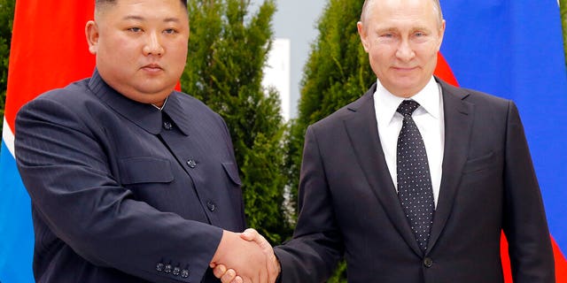 Russian President Vladimir Putin, right, and North Korea's leader Kim Jong Un shake hands during their meeting in Vladivostok, Russia