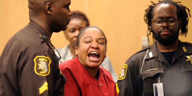 Mitchelle Blair is led out of the courtroom by Wayne County Sheriff deputies after an outburst during a custody hearing before Wayne County Circuit Judge Edward Joseph Thursday, June 4, 2015 in Detroit. She was arrested March 24 after court deputies carrying out an eviction at her apartment found the bodies of her children, Stoni Blair, 13, and Stephen Berry, 9, in a deep freezer.