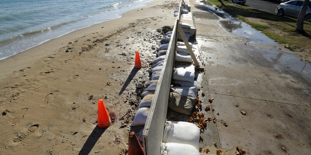 In this June 23, 2017 photo, sand bags line the beach at Ala Moana Beach Park in Honolulu as record high tides hit the islands. (Honolulu Star-Advertiser, Bruce Asato via AP)
