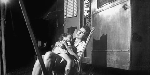 Stripper Gypsy Rose Lee holding her 4-year old son, Erik Lee Kirkland, during a stopover in traveling carnival show.