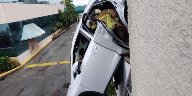 Authorities said the SUV was precariously hanging from the side of the parking garage.