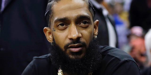 This March 29 file photo shows rapper Nipsey Hussle at an NBA game between the Golden State Warriors and the Milwaukee Bucks in Oakland. Hussle was shot and killed on Sunday outside his clothing store in Los Angeles. (AP Photo/Marcio Jose Sanchez, File)