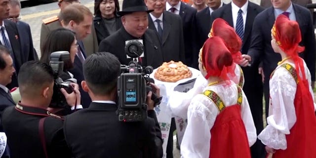North Korean leader Kim Jong Un is welcomed by girls clad in traditional Russian clothes upon arrival at Khasan train station in Primorye region, Russia, Wednesday, April 24, 2019.