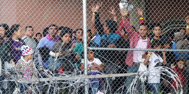 FILE: Central American migrants wait for food in El Paso, Texas, Wednesday, March 27, 2019, in a pen erected by U.S. Customs and Border Protection to process a surge of migrant families and unaccompanied minors. 
