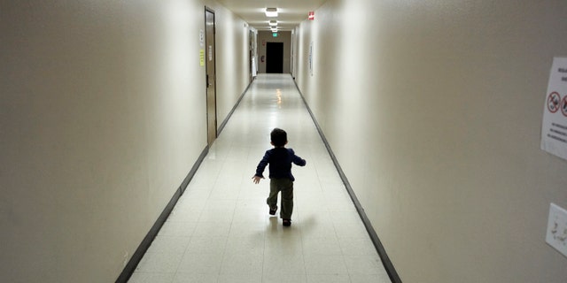 FILE - In this Dec. 11, 2018 file photo, an asylum-seeking boy from Central America runs down a hallway after arriving from an immigration detention center to a shelter in San Diego. San Diego County sued Wednesday, April 3, 2019, to overturn the Trump administration's cancelling of an immigration program that quickly released families after they cross the border without allowing time for travel arrangements. (AP Photo/Gregory Bull, File)