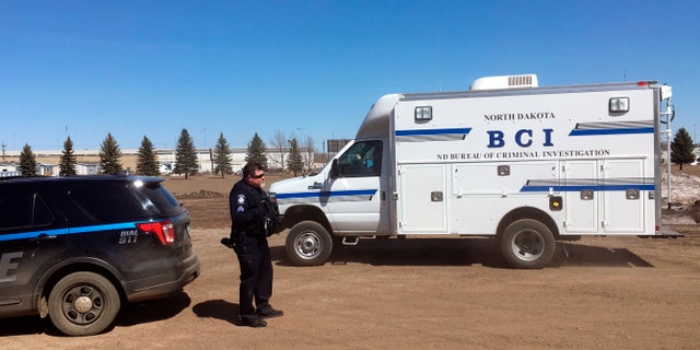 In this Wednesday, April 3, 2019 photo, state and local police search a field in Manton, N.D., about half a mile from a business where an owner and three employees were found dead. (Associated Press)