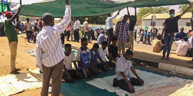 Protesters pray during a demonstration near the military headquarters, Tuesday, April 9, 2019, in the capital Khartoum, Sudan. Activists behind anti-government protests in Sudan say security forces have killed at least seven people, including a military officer, in another attempt to break up the sit-in outside the military headquarters in Khartoum. A spokeswoman for the Sudanese Professionals Association, said clashes erupted again early Tuesday between security forces and protesters who have been camping out in front of the complex in Khartoum since Saturday. (AP Photo)