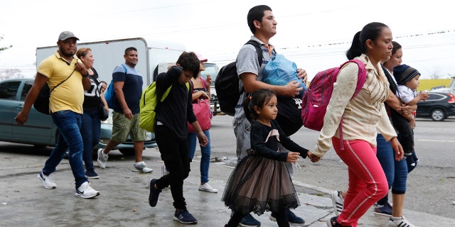Migrants walk along a highway as a new caravan of several hundred people sets off in hopes of reaching the distant United States, in San Pedro Sula, Honduras, shortly after dawn Wednesday, April 10, 2019. Parents who gathered at the bus station with their children to join the caravan say they can't support their families with what they can earn in Honduras and are seeking better opportunities. (AP Photo/Delmer Martinez)