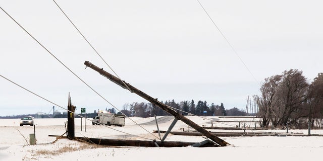 A row of power line poles are snapped from ice and wind along Hwy. 56 south of Interstate 90 on Thursday, April 11, 2019, near Browndale, Minn. A powerful spring snow storm is creating hazardous travel conditions in parts of the Midwest and Great Lakes regions. (Andrew Link/The Rochester Post-Bulletin via AP)