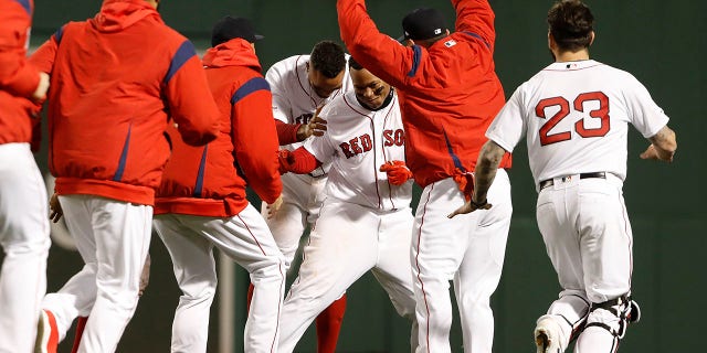 Boston Red Sox's Rafael Devers is congratulated by teammates after his walk-off single against the Toronto Blue Jays Thursday.