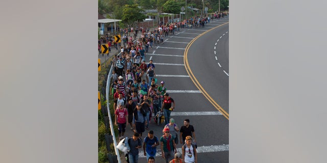 Central American migrants, part of a caravan hoping to reach the U.S. border, walk on the shoulder of a road in Frontera Hidalgo, Mexico on Friday. (Associated Press)