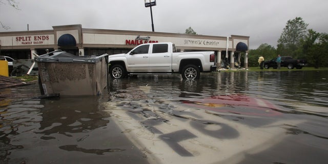Debris is scattered in the flooded waters in the Pemberton Quarters mall after Saturday's weather in Vicksburg, Miss. (Associated Press)