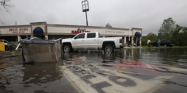 Debris is scattered in the flooded waters in the Pemberton Quarters mall after Saturday's weather in Vicksburg, Miss. (Associated Press)