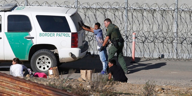 Honduran asylum seekers are taken into custody by U.S. Border Patrol agents in San Diego this past Demceber. (AP Photo/Moises Castillo, File)