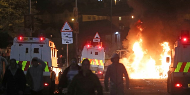 A car burns after petrol bombs were thrown at police in Creggan, Londonderry, in Northern Ireland, Thursday, April 18, 2019.