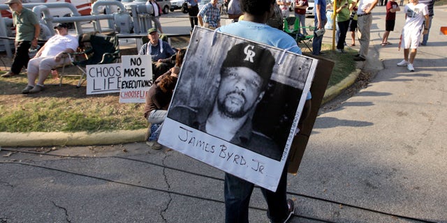 FILE - In this Sept. 21, 2011, file photo, Ricky Jason wears a photo of James Byrd Jr. outside the Texas Department of Criminal Justice Huntsville Unit before the execution of Lawrence Russell Brewer in Huntsville, Texas. (Associated Press)