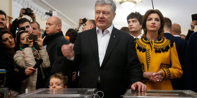 moves Ukrainian President Petro Poroshenko as he speaks to the media when his wife Maryna stands beside him at a polling station under second round presidential elections in Kiev, Ukraine, Sunday, April 21, 2019. Top issues in the election have been corruption, the economy and how to end the conflict with Russian-backed rebels in eastern Ukraine. ()