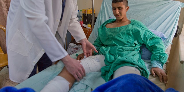 A doctor checks Osama Hajahjeh, 16, at Beit Jala Hospital near the city of Bethlehem in the West Bank, Monday, April 22, 2019. (AP Photo / Nasser Nasser)