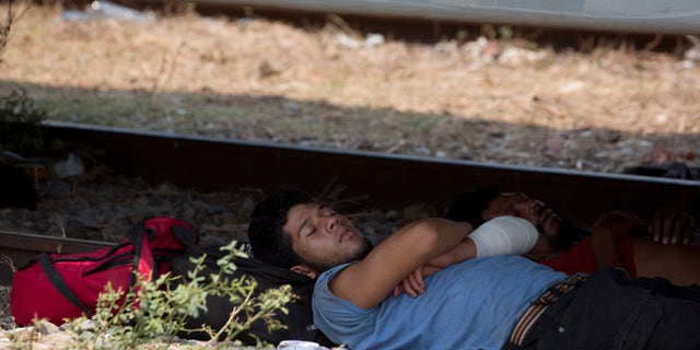 A Central American migrant takes a nap in the shade under a freight train car, during his journey toward the US-Mexico border, in Ixtepec, Oaxaca State, Mexico, Tuesday, April 23, 2019. (AP Photo/Moises Castillo)