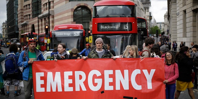 Extinction Rebellion climate change protesters briefly block the road in the City of London, Thursday April 25, 2019. Nonviolent protest group Extinction Rebellion are seeking negotiations with the Government over their call for slowing climate change to be a top priority.