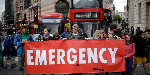 Extinction Rebellion climate change protesters briefly block the road in the City of London, Thursday, April 25, 2019. The non-violent protest group, Extinction Rebellion, is seeking negotiations with the government on its demand to make slowing climate change a top priority.