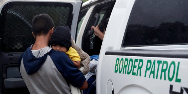 Families who crossed the U.S.-Mexico border are placed in a Border Patrol vehicle.(AP Photo/Eric Gay)