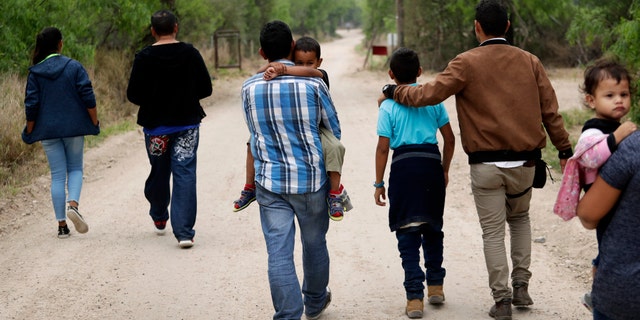 FILE - In this March 14, 2019, file photo, a group of migrant families walk from the Rio Grande, the river separating the U.S. and Mexico in Texas, near McAllen, Texas, right before being apprehended by Border Patrol. U.S. border authorities say they’ve started to increase the biometric data they take from children 13 years of age and younger, including fingerprints, despite privacy concerns and government policy intended to restrict what can be collected from migrant youth. (AP Photo/Eric Gay, File)
