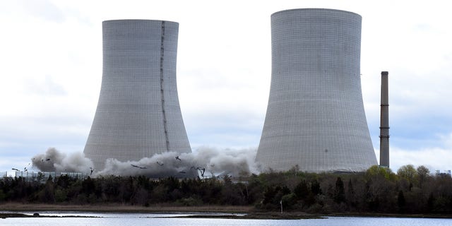 The two 500-foot cooling towers of the old Brayton Point Railway Station begin to collapse after the release of an explosive charge in Somerset, Massachusetts.