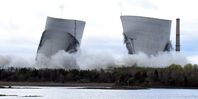 The two 500-foot cooling towers of the old Brayton Point train station collapsed after explosive charges exploded in Somerset, Massachusetts.