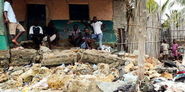 Community members look at rubble and other items washed close to their doorstep when Cyclone Kenneth struck in Pemba city on the northeastern coast of Mozambique, Saturday, April, 27, 2019. (AP Photo/Tsvangirayi Mukwazhi)