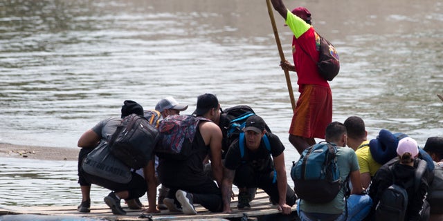 Migrants cross the border between Mexico and Guatemala, on a raft over the Suchiate river near Ciudad Hidalgo, Chiapas state, Mexico, Saturday, April 27, 2019. Thousands of migrants remain on the southern border of Mexico waiting for documents that allow them to stay legally in the country. (AP Photo/Moises Castillo)