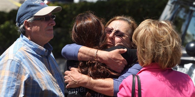 Members of the Chabad Synagogue hug near the Altman Family Chabad Community Center on Saturday in Poway, California. (Associated Press)